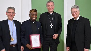Dem in Kamerun geborenen Theologen Dr. des. Bruno Kono wurde feierlich das Promotionszeugnis überreicht. Dabei war auch sein Doktorvater, Prof. Dr. Christoph Gregor Müller (rechts), gemeinsam mit dem Großkanzler der Theologischen Fakultät Fulda, Bischof Dr. Michael Gerber, und Rektor Prof. Dr. Cornelius Roth (links).  Foto: Bistum Fulda / Arnulf Müller